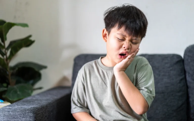 Young boy experiences a toothache from a cavity