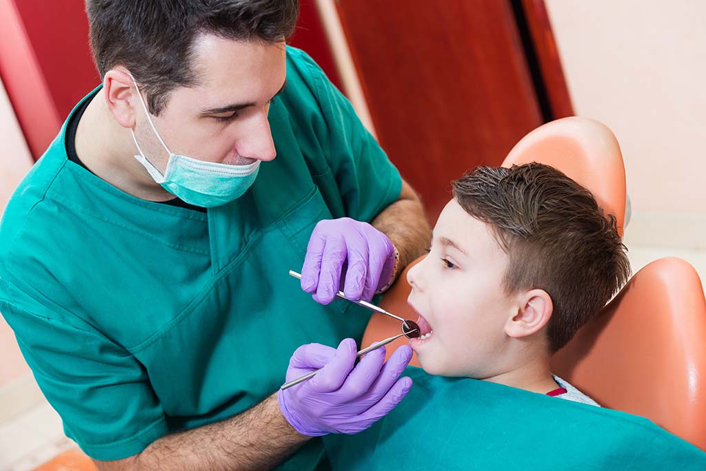 Young boy has his teeth examined by a pediatric dentist