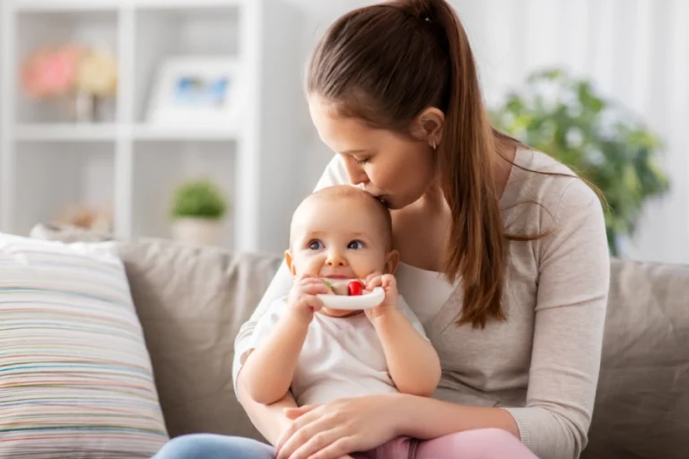 Caucasian mother with brown hair holds teething baby