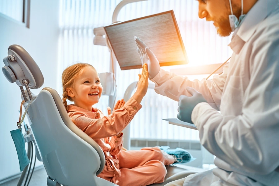 Little girl high-fiving a dentist