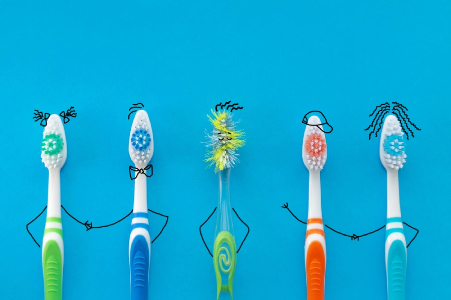 Stick figures made from toothbrushes join hands against a bright blue background